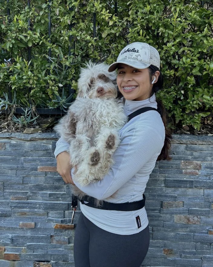 Mariam holding one of the dogs she looks after